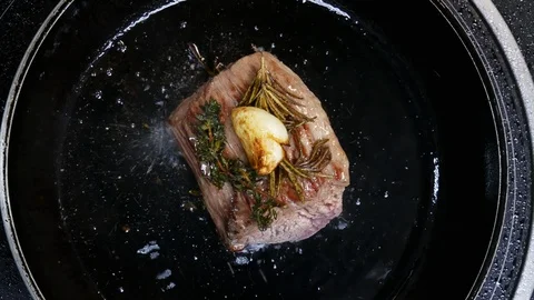 Top view of Large steak is fried in a frying pan in the kitchen of the Stock Footage 115999268