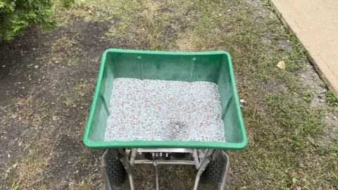 Top view of a lawn fertilizer spreader cart filled with mineral granules Stock Footage 342087459
