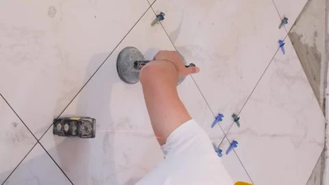 Top view of laying ceramic tiles using tools and adhesive mixtures. Vertical Stock Footage 250030229