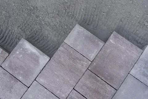 Top view of laying large rectangular paving stones on prepared ground Stock Photos