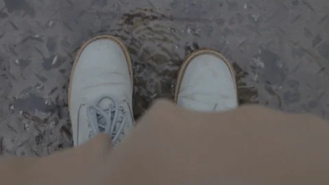 Top view of legs standing in a puddle along the road Video stock 106315050