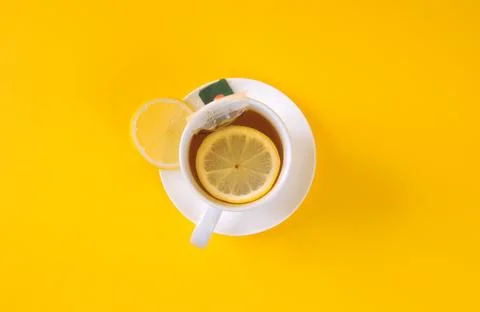 Top view of lemon tea with sliced lemon on yellow background Stock Photos