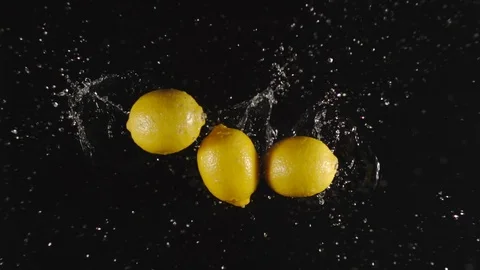 TOP VIEW: Lemons fall in a water, splashing - Slow motion Stock Footage 115319010