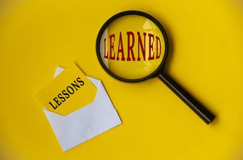 Top view of lessons learned text on envelope and magnifying glass. Foto stock
