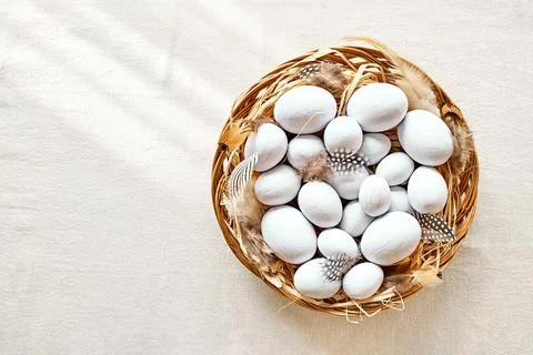 Top view of  light blue easter eggs with feathers in the nest on linen text.. Stock Photos