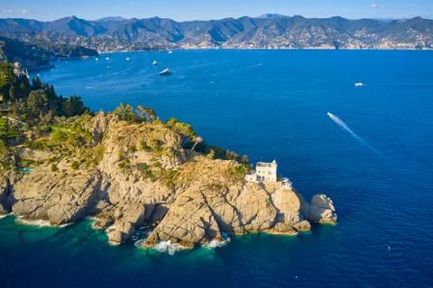 Top view on a lighthouse standing on the rocky hill near the sea with blue Stock Photos