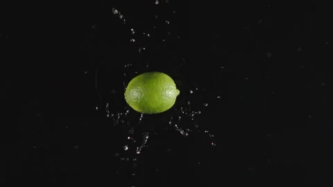 TOP VIEW: Lime falls in a water, splashing - Slow motion Vídeos de archivo 161687993