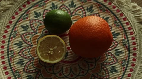 Top view of lime, orange and halved lemon on embroidered napkin, flat lay Stock Footage 346252067