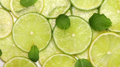 Top view of lime slices and fresh mint leaves arranged in bright composition. Stock Footage 305923362