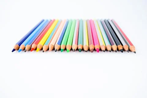 Top view of a line of some different colored pencil crayons arranged on a whi Stock Photos