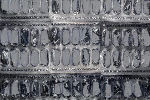 Top view of lined empty foil blister packages on white background Stock Photos