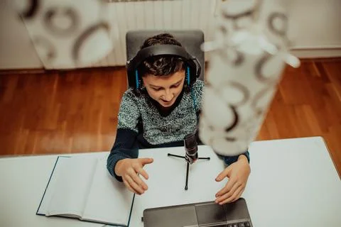 Top view, the little boy using laptop and headphones studying math during his Stock Photos