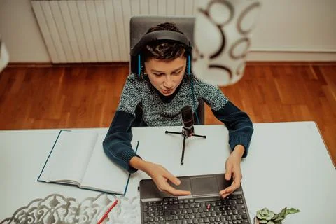 Top view, the little boy using laptop and headphones studying math during his Foto stock
