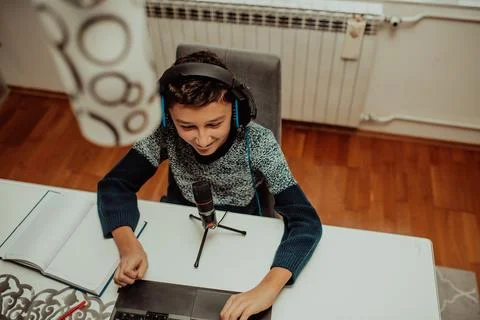 Top view, the little boy using laptop and headphones studying math during his Foto stock