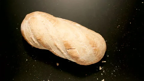TOP VIEW: Loaf Of Bread Falling Down On A Black Surface Stock Footage 167990821