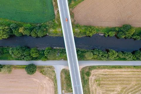 Top view of a long bridge passing through green fields Stock Photos