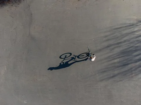 Top view of long shadow of a man on a bicycle Stock Photos