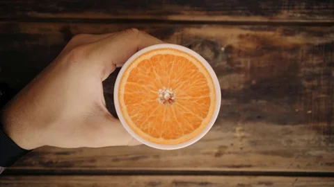 Top view loop of hand holding cup with orange inside Video stock 79354840