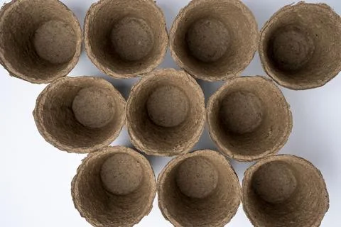 Top view of a lot of empty peat pots for seedlings on a white background Stock Photos