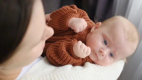 Top view of loving young mother holding adorable newborn baby in her arms Stock Footage 253998560