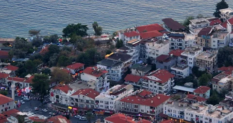 Top view of low buildings with red tiled roofs of small resort town on shores of Stock Footage 222965292