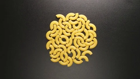 TOP VIEW: Macaroni shake on a black table (stop motion) Stock Footage 69809432