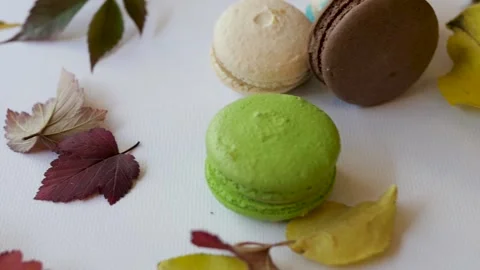 Top view of macarons on a white background surrounded by autumn leaves. autumn Видео 139149031