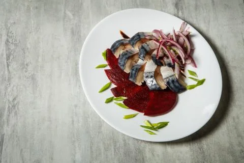 Top view on mackerel and beetroot slices with chopped red and green onion ser Stock Photos