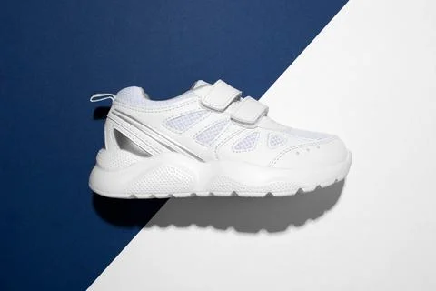 Top view macro on one white teen sneaker on the side with velcro fasteners fo Stock Photos