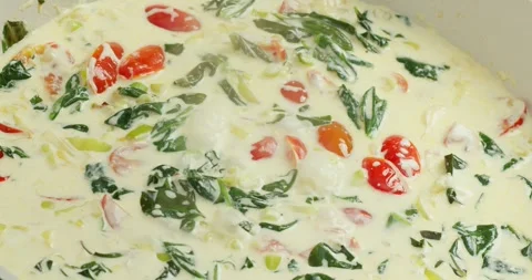Top view macro shot Tomatoes simmering with spinach leaves and green onions in Stock Footage 317405214