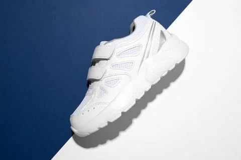 Top view macro on the side one white sneaker with Velcro fasteners for easy f Stock Photos