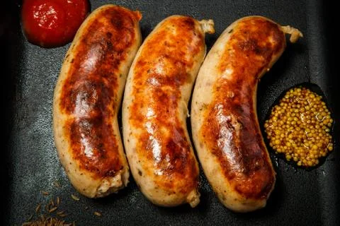 Top view macro square pan with three fried sausages Fotos de archivo