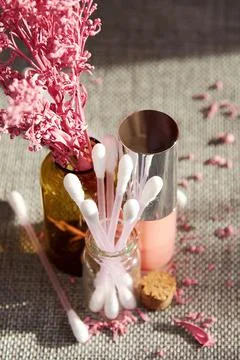 Top view of makeup desk with lip gloss and cotton buds with a decorative lilac Foto stock