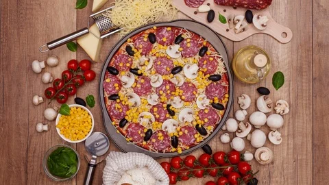 Top view of making a pizza with ingredients appearing on the rotating setting 動画素材 86859712