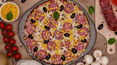 Top view of making a pizza with ingredients appearing - stop motion animation 스톡 동영상 86860130