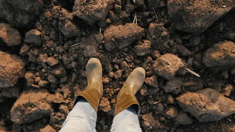 Top view male farmer in rubber boots standing on plowed field Stock Footage 142641453