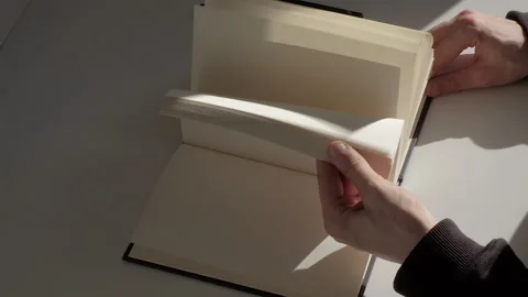 Top view: male hands quickly flipping through the white pages of the diary Stock Footage 229896090
