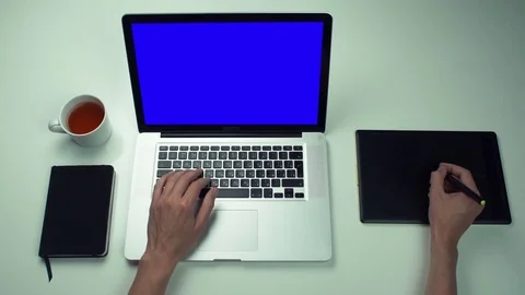 Top view male hands using graphic tab and laptop with green screen at white desk Stock Footage 82887910