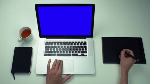 Top view male hands using graphic tab and laptop with green screen at white desk Stock Footage 82887991