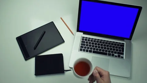 Top view male hands using graphic tab and laptop with green screen at white desk Stock Footage 82890954