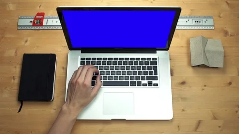 Top view male hands using laptop with green screen at wooden desk Stock Footage 82898821