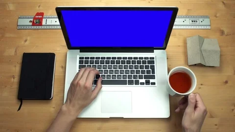 Top view male hands using laptop with green screen at wooden desk Stock Footage 82898922