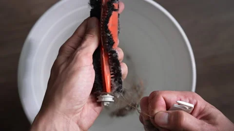 Top view of male hands using small tool to clean tangled hair and dust from Stock Footage 342754533