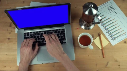 Top view male hands working with printed graphs using laptop with green screen Stock Footage 82887796
