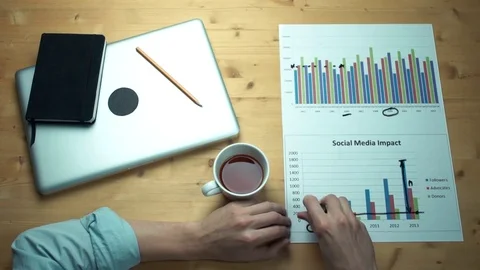 Top view male hands working with printed graphs erasing notes from plastic glass Stock Footage 82902820