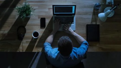 Top View of Male Programmer Writing Code on His Desktop Computer at Night. Stock Photos