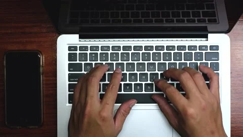 Top view, Male's hand typing on white laptop on wooden desk. Stock Footage 171157832
