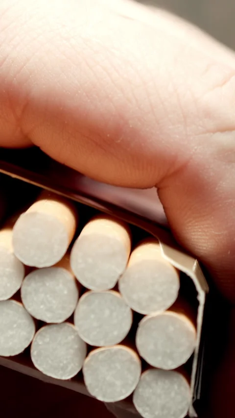 TOP VIEW: Man abruptly lifts the pack and takes a cigarette from it 스톡 동영상 344858929