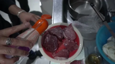 Top view of a man adding barbecue salt to various pieces of meat in the kitchen Stock Footage 155789210