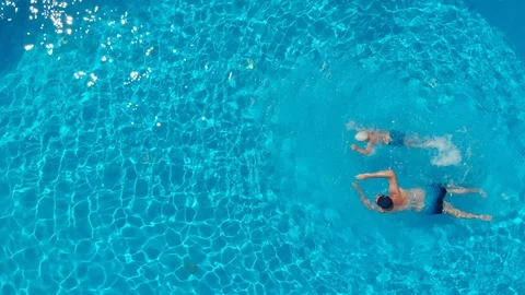 A top view of a man and a boy swimming in a clear open swimming pool Vídeo Stock 122430070